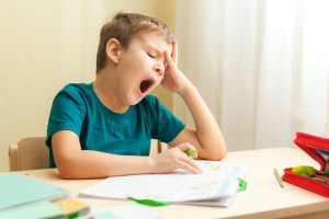 A child yawning at a table