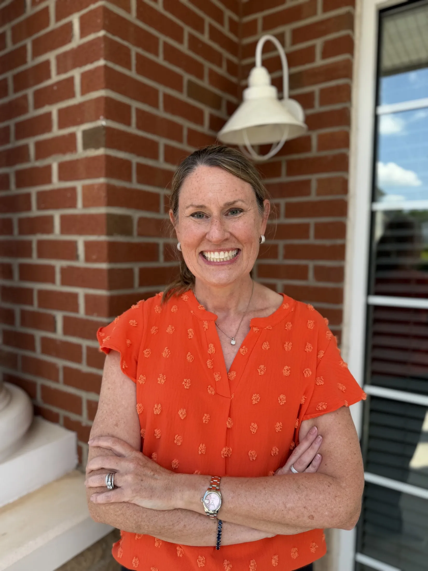 Dr. Bird smiling outside of her dental practice for a headshot
