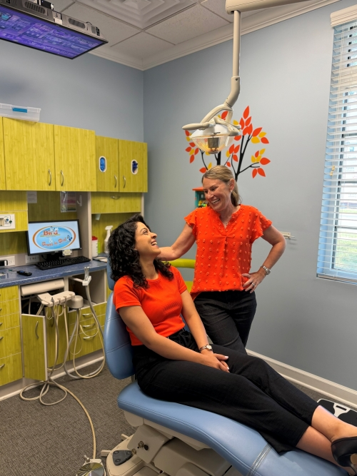 Dr. Bird smiling at Dr. Shekari in dental cleaning chair