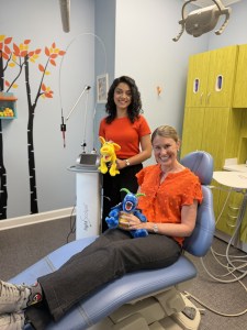Dr. Bird and Dr. Shekari smiling in dental cleaning chair with Stuffed Animals
